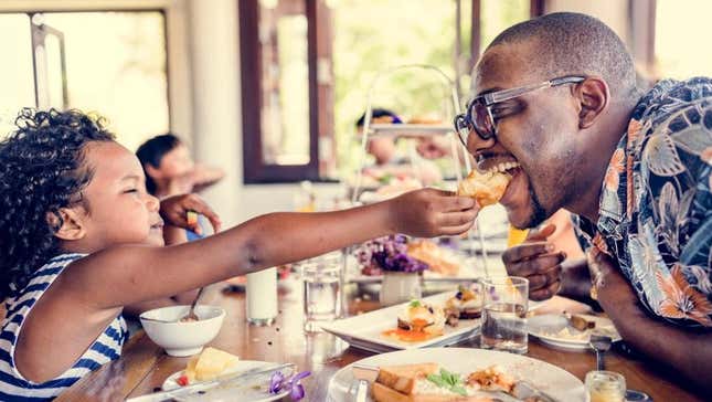 Parent and child eating at restaurant