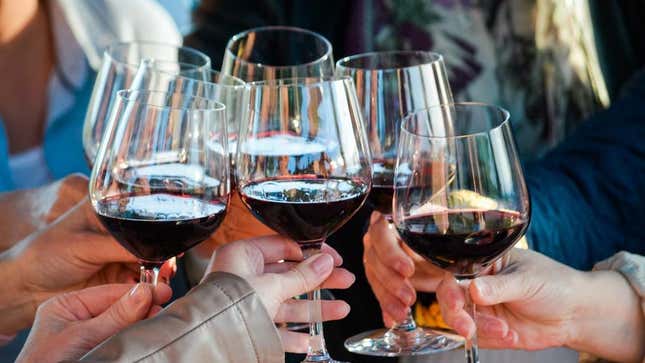 Friends holding glasses of red wine in toast