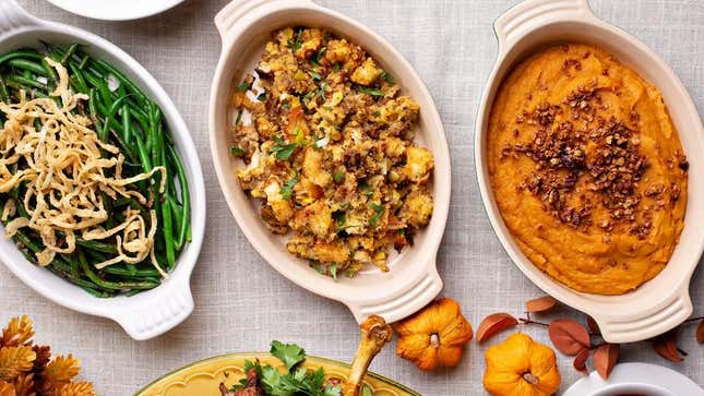 Dishes of Thanksgiving stuffing, green beans, and sweet potatoes