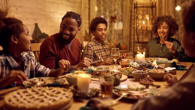 Family gathered around Thanksgiving dinner, laughing
