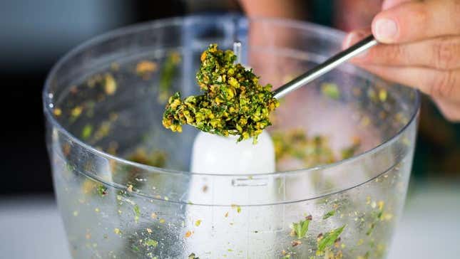 Homemade pesto on spoon by food processor