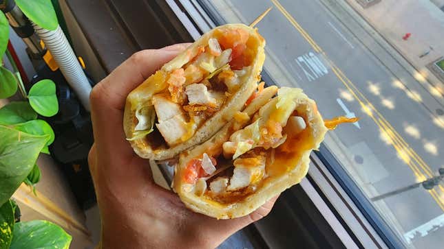 Hand holding chicken pita to show interior
